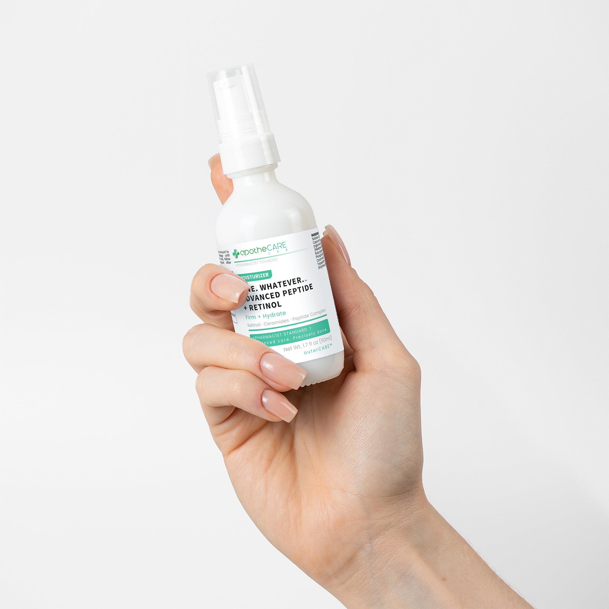 Hand holding a skincare product bottle with a white background