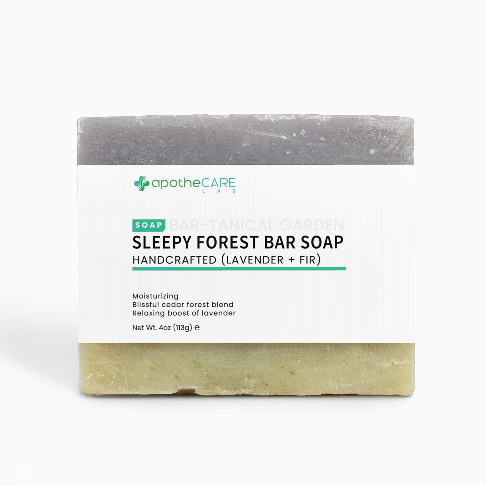 A bar of soap labeled 'apothecare lab Sleepy Forest Bar Soap' with a white paper label, showing a dark gray top half and a pale yellow-green bottom half, on a light gray background.