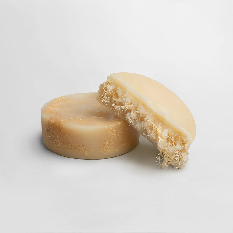 Bar of soap with a natural texture on a light gray background