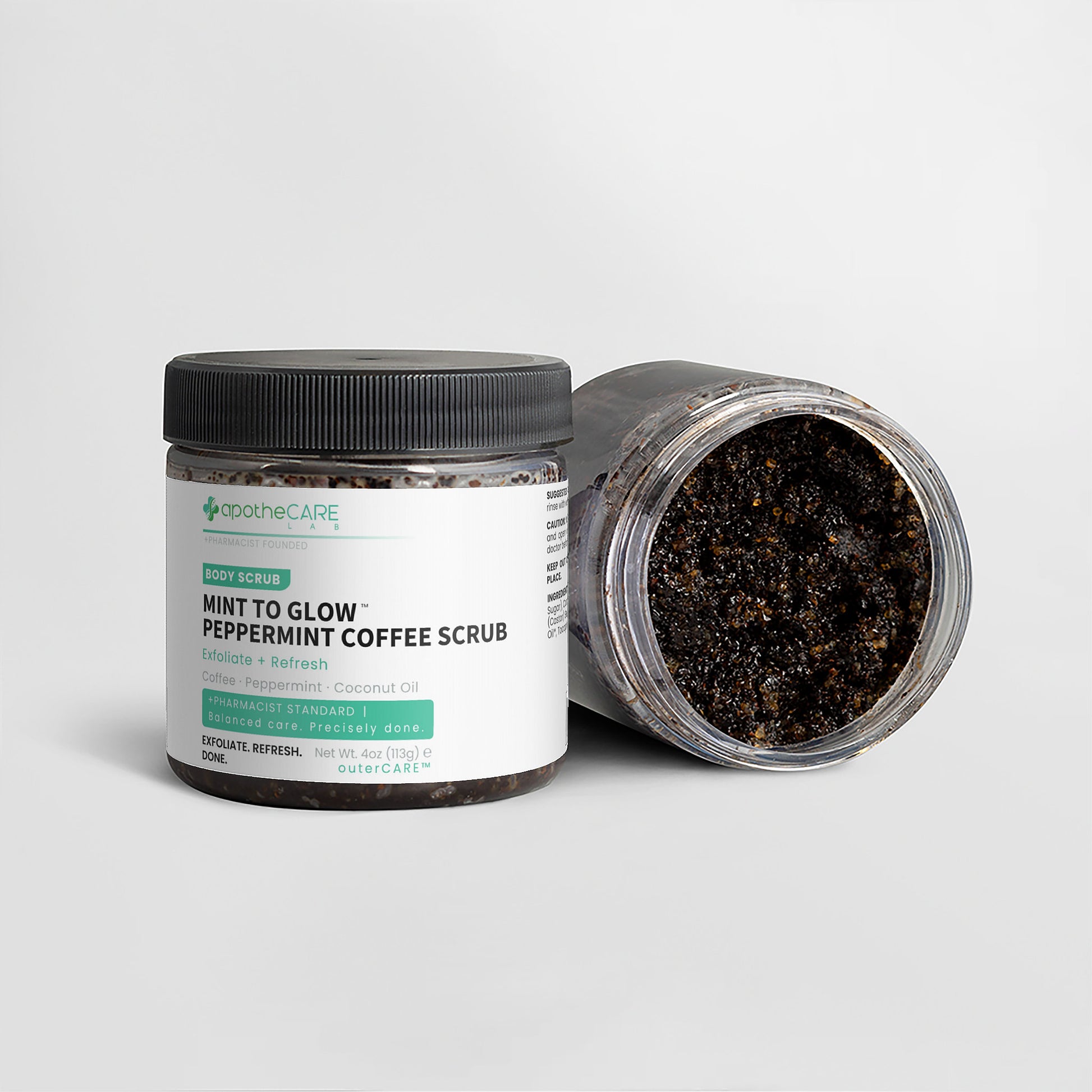 Two jars of apotheCARE LAB Mint to Glow Peppermint Coffee Scrub on a light gray background, with one jar open to show the dark scrub inside.