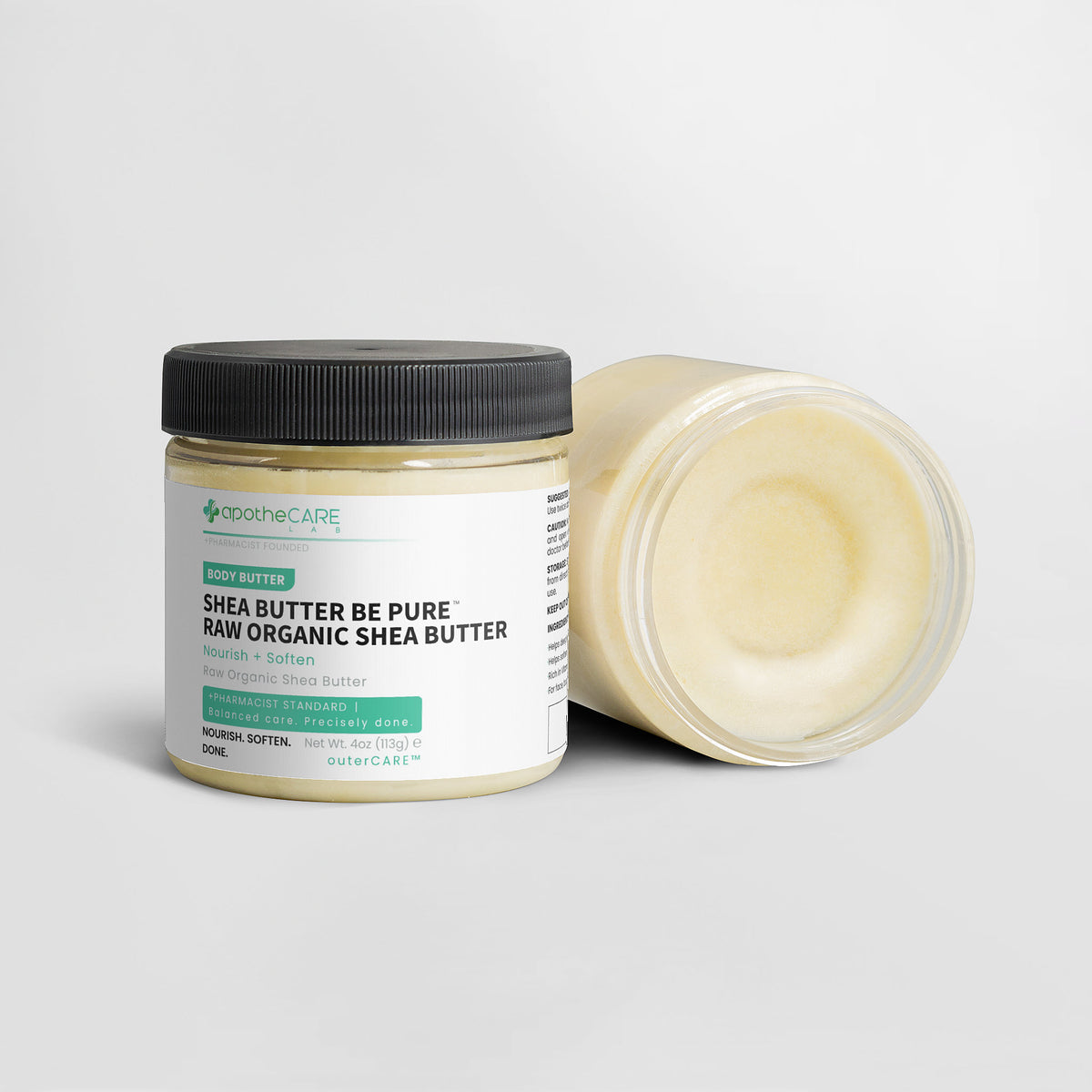 A jar of apotheCare Raw Organic Shea Butter with a black lid, standing next to an open jar showing the creamy pale yellow shea butter inside, on a light gray background.