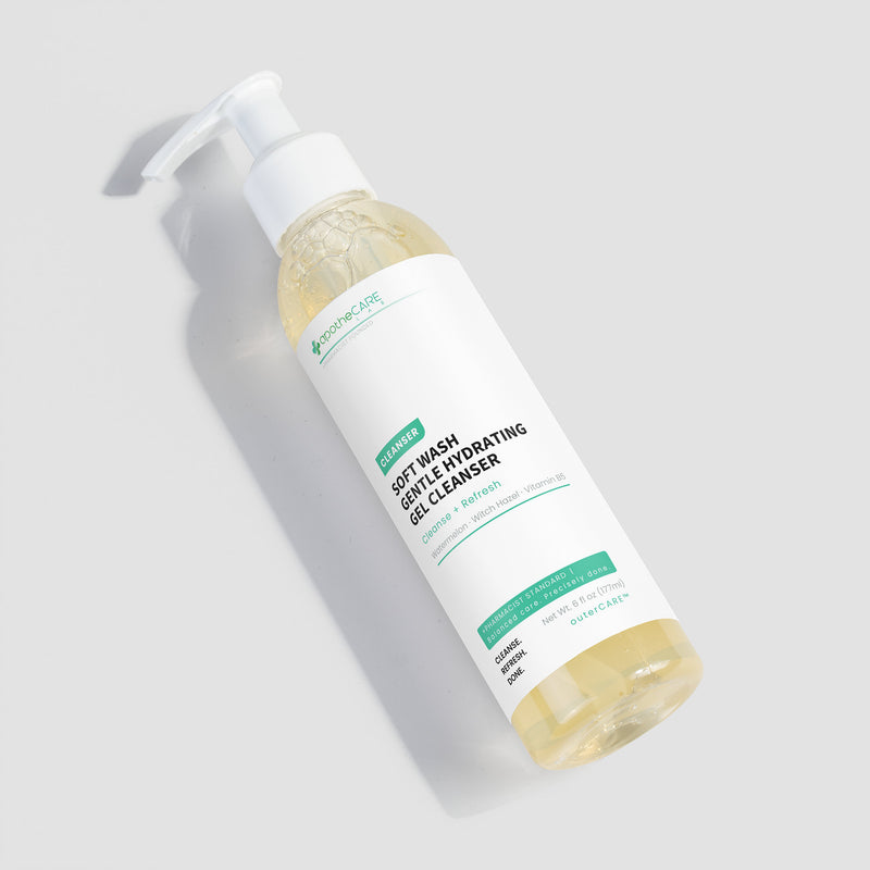 A bottle of Soft Wash Softly Hydrating Gel Cleanser, filled with a pale yellow gel, shown on a light gray background with a soft shadow.