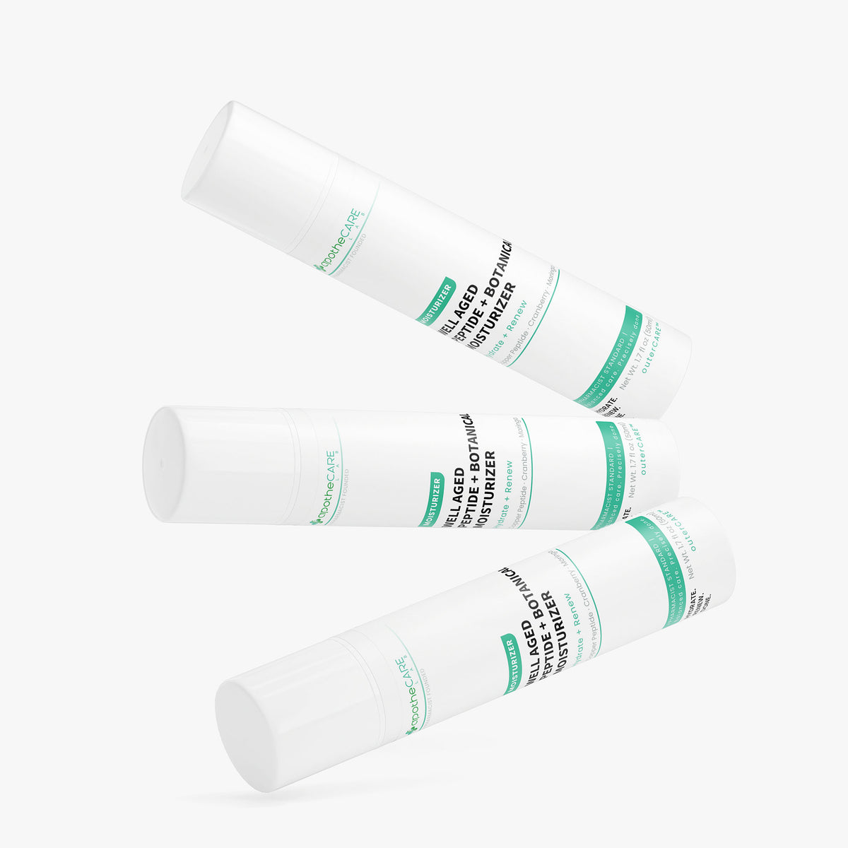 Three white cylindrical cosmetic tubes with green and black text, arranged diagonally on a light gray background.