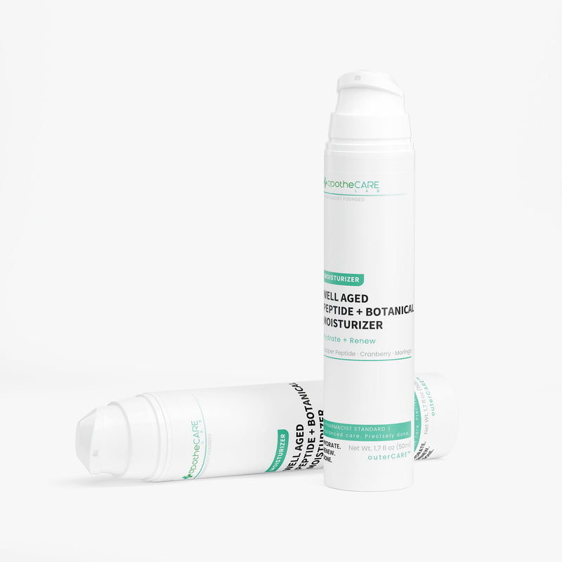 Two white bottles of apotheCARE Well Aged Peptide + Botanical Moisturizer, one standing upright and one lying on its side, on a clean white background.