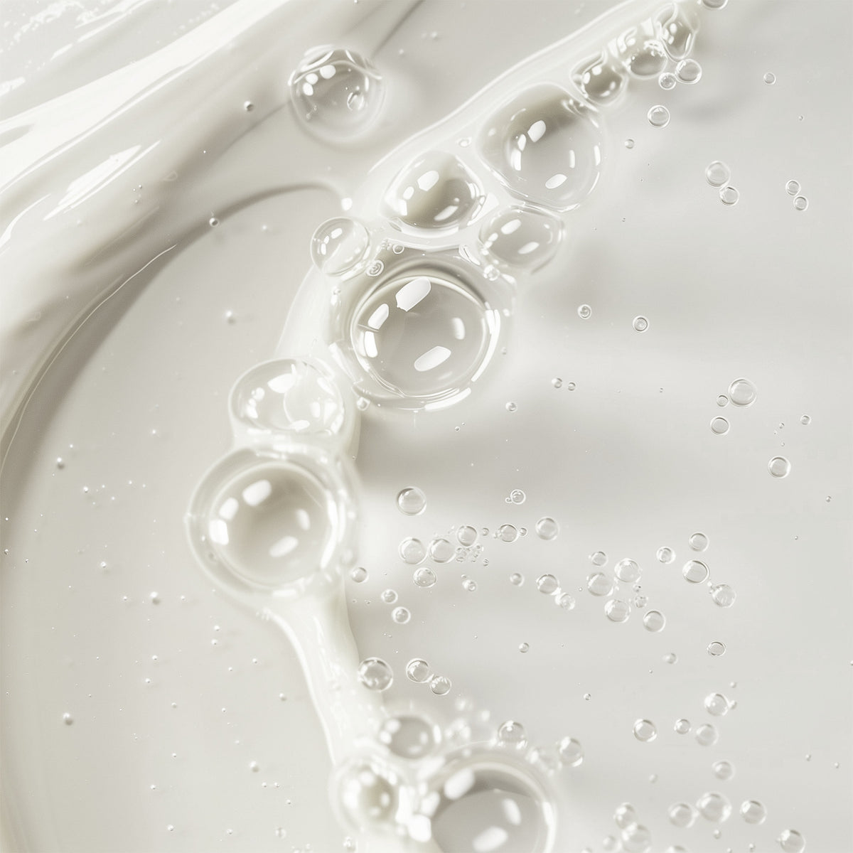Close-up of white liquid with bubbles on a light gray background