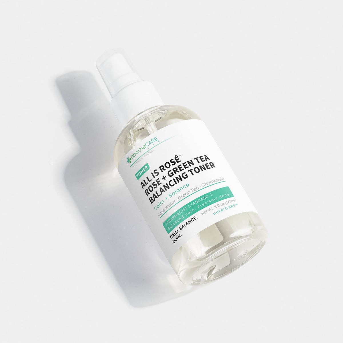 A clear plastic spray bottle of apotheCARE LAB All Is Rosé + Green Tea Balancing Toner, featuring a white label with green and black text, set against a clean white background with a soft shadow.