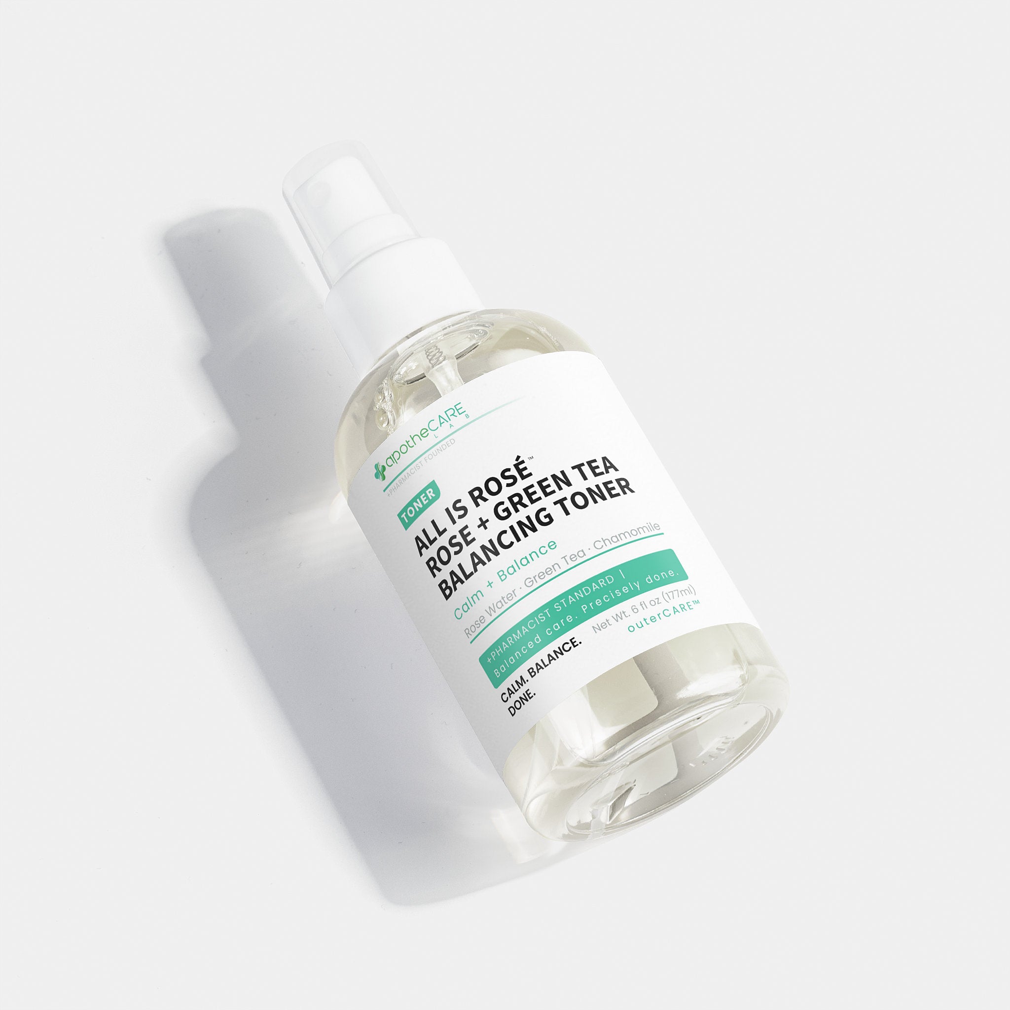 A clear plastic spray bottle of apotheCARE LAB All Is Rosé + Green Tea Balancing Toner, featuring a white label with green and black text, set against a clean white background with a soft shadow.