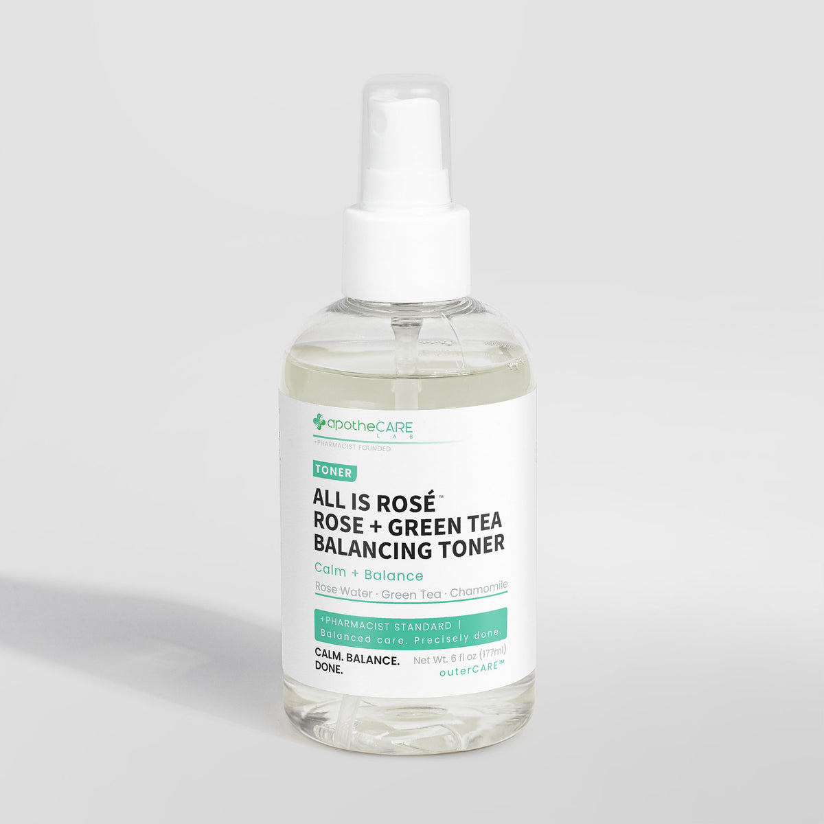 A clear plastic spray bottle of apotheCare All Is Rosé Rose + Green Tea Balancing Toner with a white pump dispenser and a white label, set against a light gray background.
