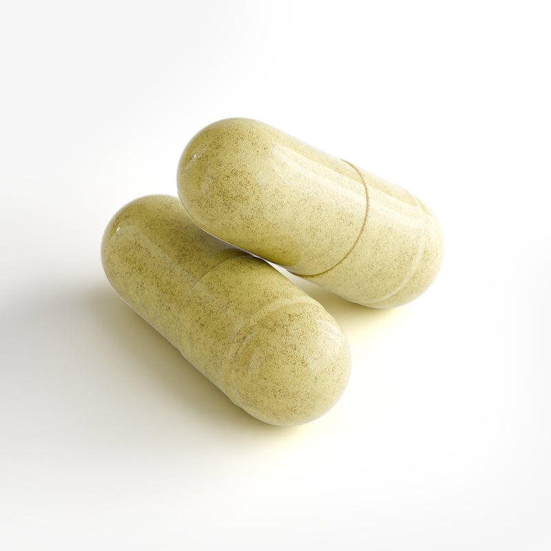 Two green yellow capsules on a white background