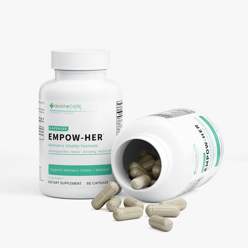 A white bottle of apotheCARE Empow-Her dietary supplement capsules stands upright next to another tipped-over bottle showing loose capsules inside, with several capsules scattered in front on a light gray background.