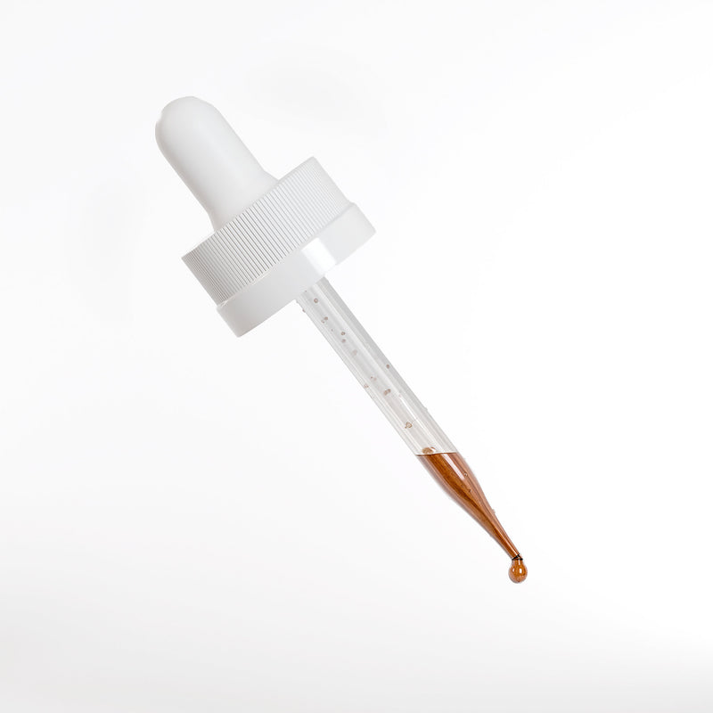 White dropper with brown liquid on a light gray background