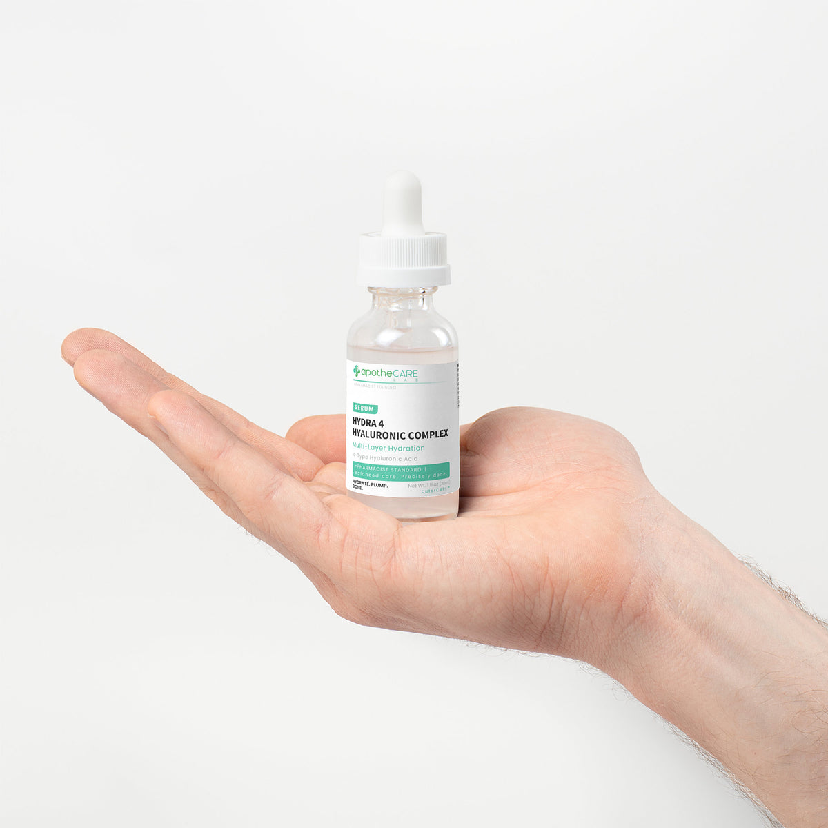 A hand holding a small glass dropper bottle labeled 'Hydra 4 - Hyaluronic Complex' against a clean white background.