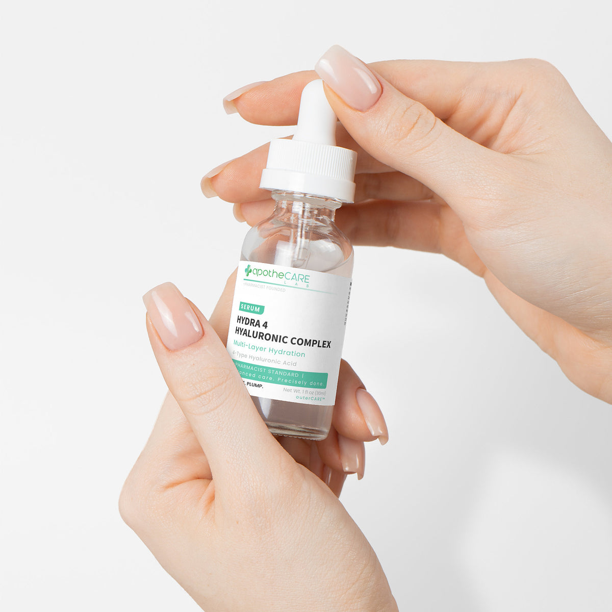 Hand holding a bottle of hyaluronic acid serum with a white background