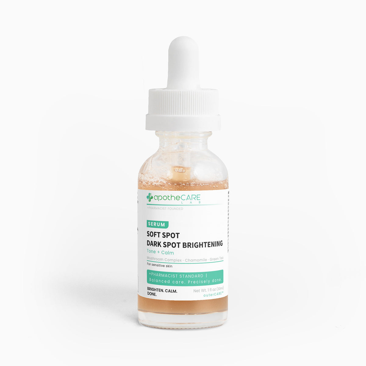 A clear glass dropper bottle of apotheCARE Soft Spot Dark Spot Brightening Serum with a white cap and white label, containing a light peach-colored liquid, set against a plain white background.