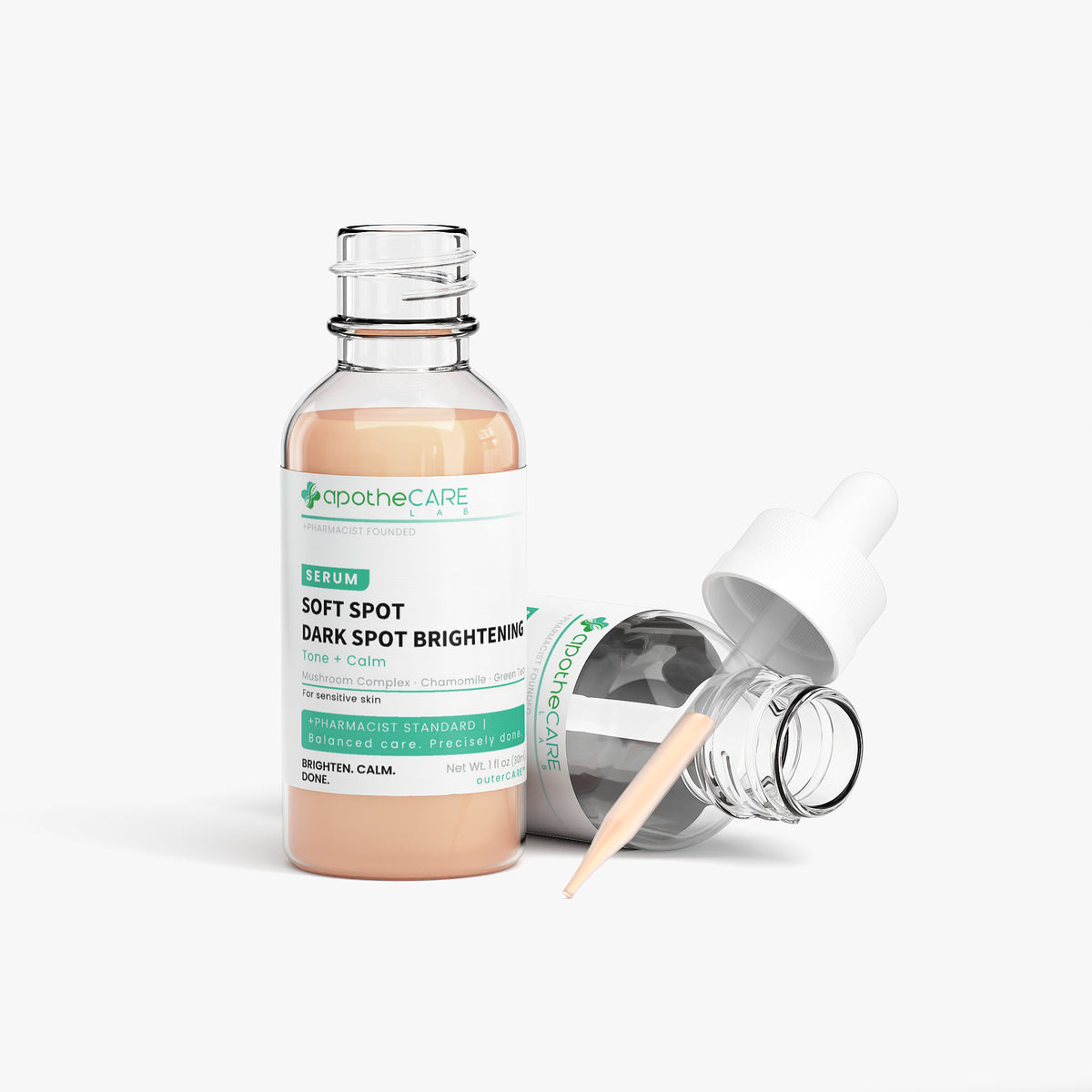 A glass bottle of apothecare lab Soft Spot Dark Spot Brightening Serum with a white dropper cap lying beside it on a clean white background.