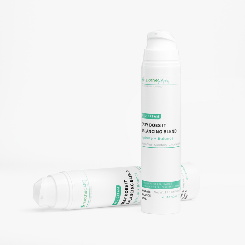 Two white bottles of apotheCARE LAB Easy Does It Balancing Blend skin cream, one standing upright and one lying on its side, on a clean white background.