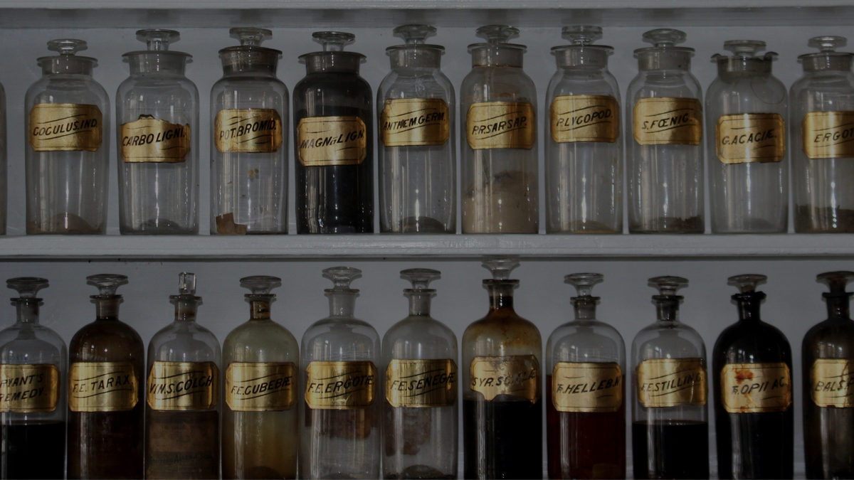 Collection of vintage glass bottles with labels on a shelf
