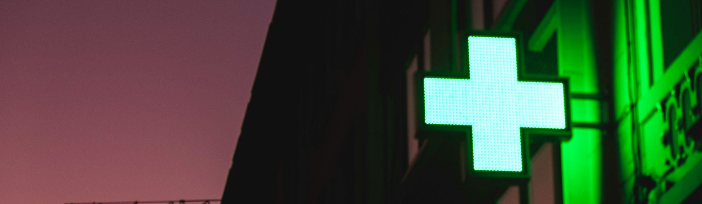 Green pharmacy sign against a dark background